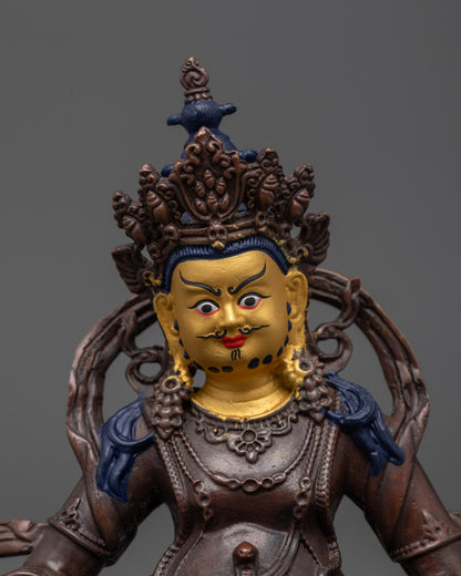 Close up of intricate carvings on oxidized Dzambhala statue showing spiritual details