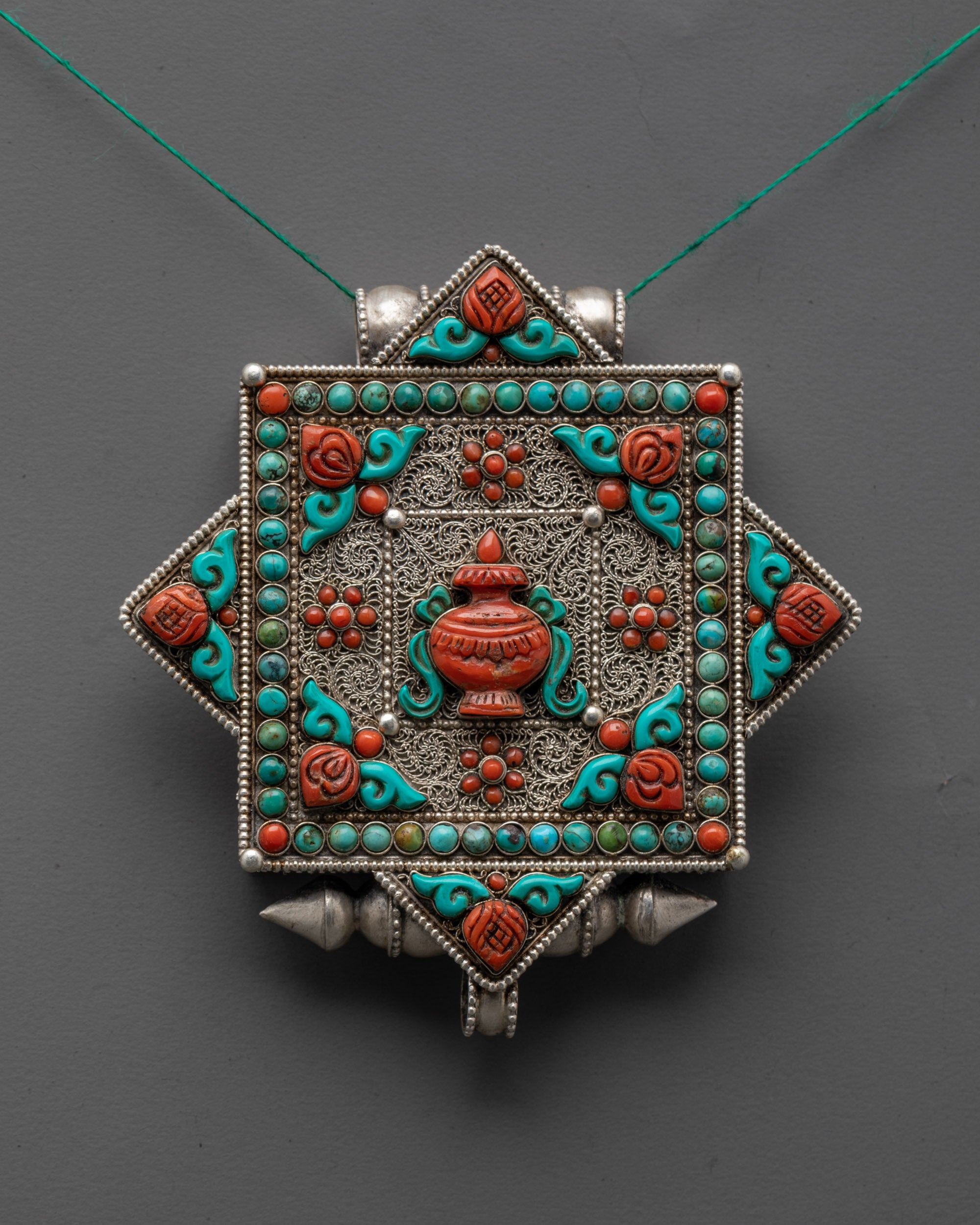 Close up of intricate silver-plated filigree design on Tibetan Treasure Vase Locket pendant
