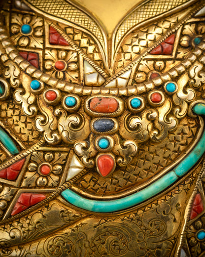 Close up of jewelry on Guru Rinpoche highlighting semi-precious stones and gold
