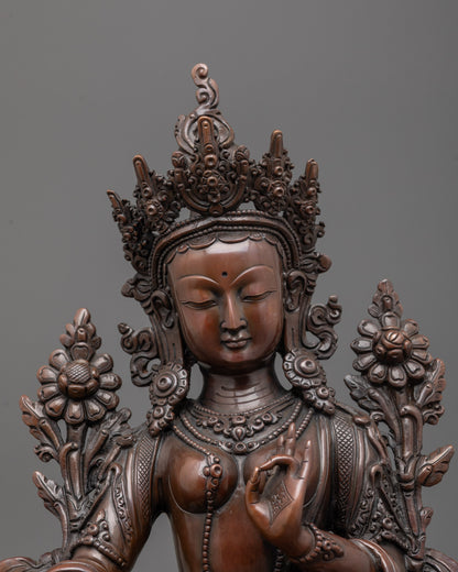 Close up of oxidized copper face and five-jeweled crown on Green Tara statue handcrafted art.