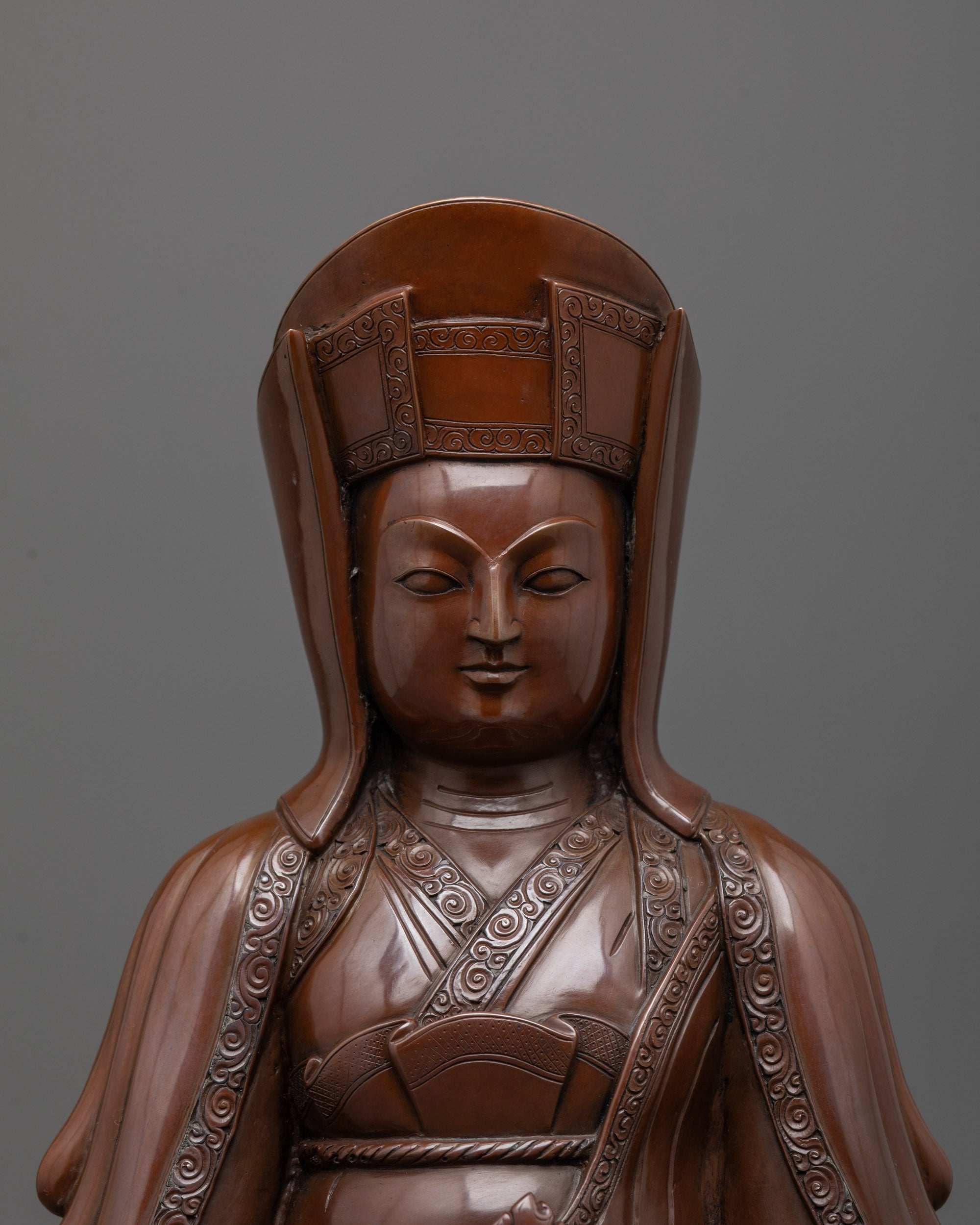 Close up of oxidized copper face and hand-carved cintamani on Lama Gampopa Statue