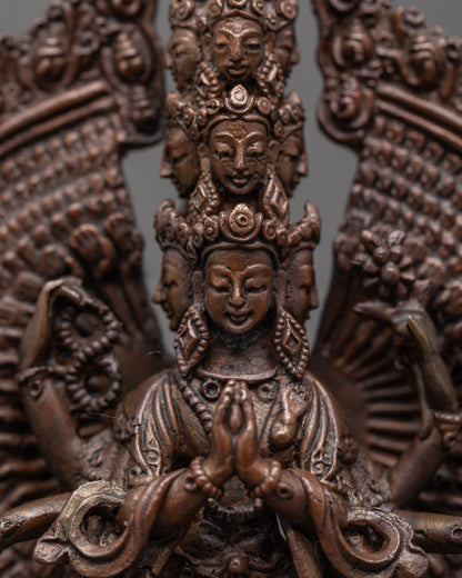 Close up of oxidized copper face and hands holding sacred symbols on Chenrezig statue