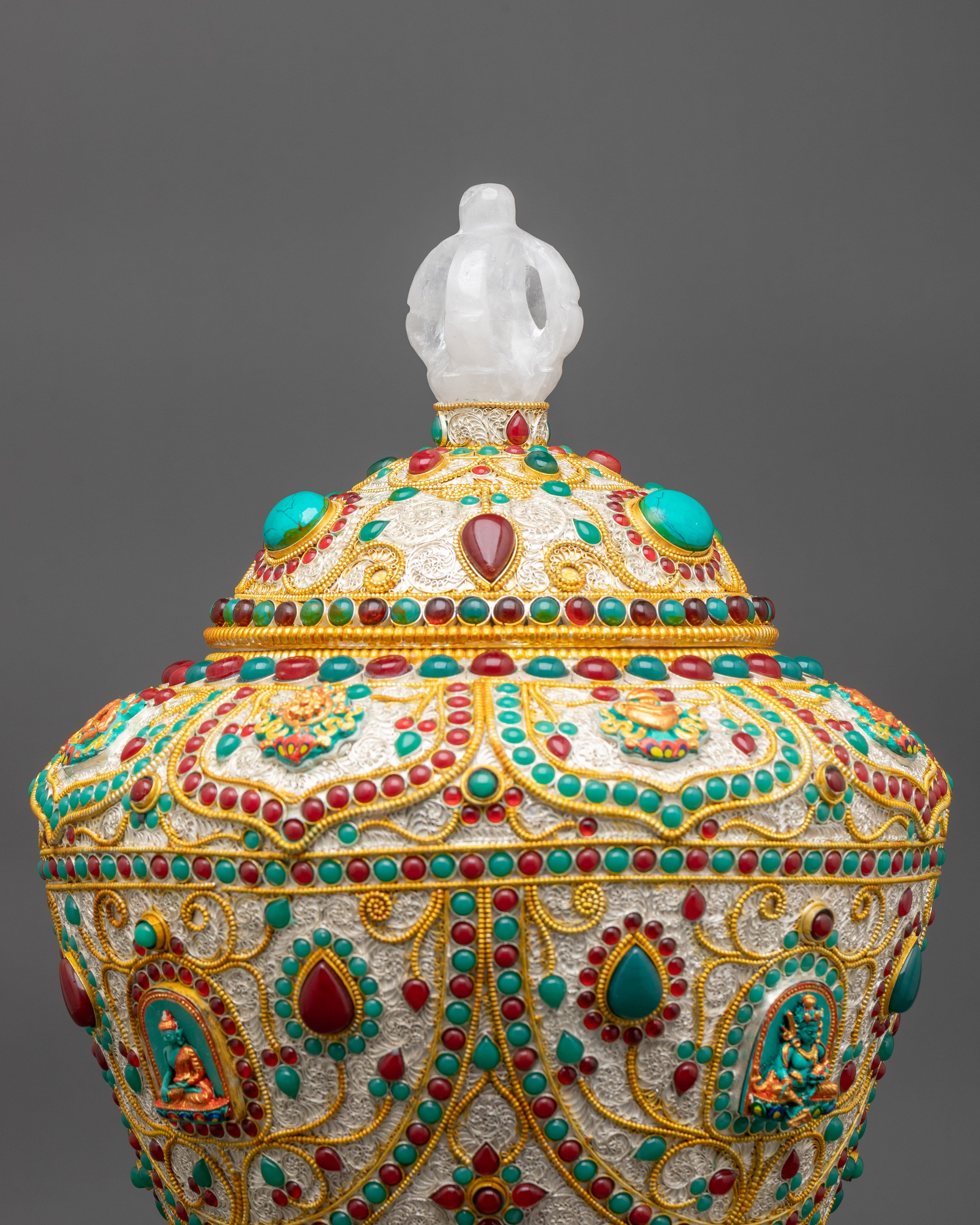 Close up of rice pot showing ruby, turquoise, emerald and engraved Buddhist symbols