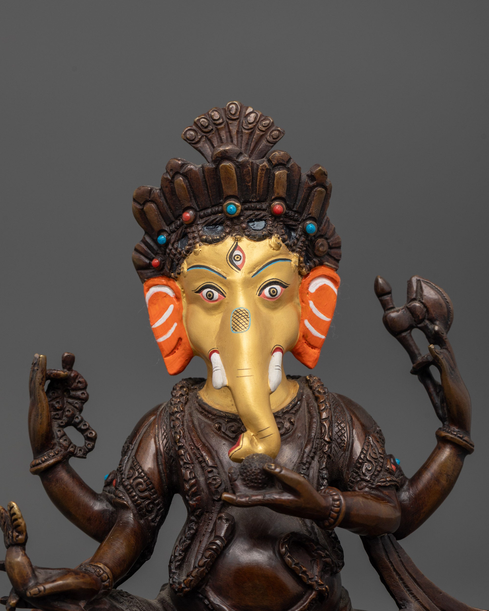 Close up of semi-precious stone crown and robe on handcrafted oxidized Ganesha statue