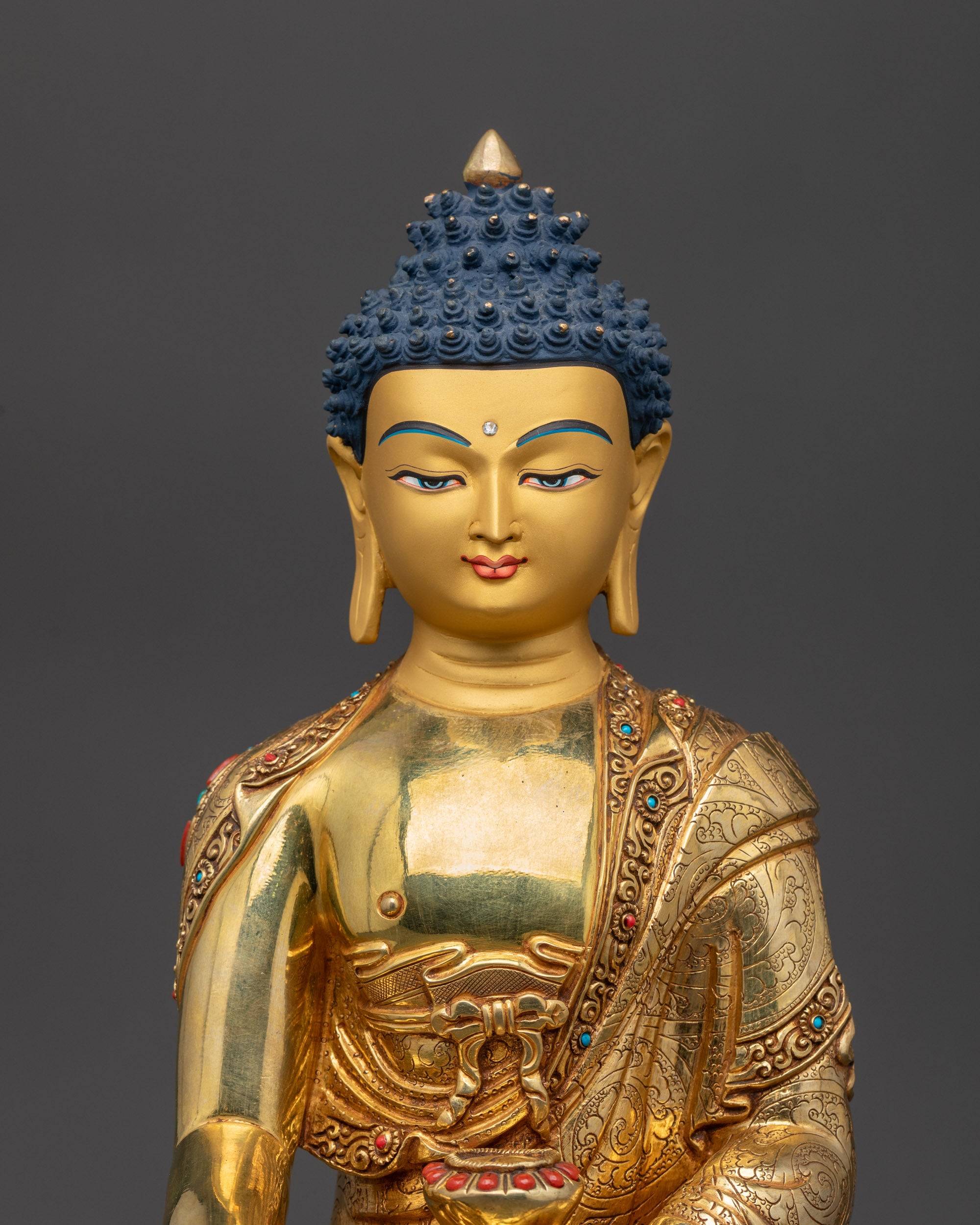 Close up of serene Shakyamuni Buddha face with intricate carved monk robe details