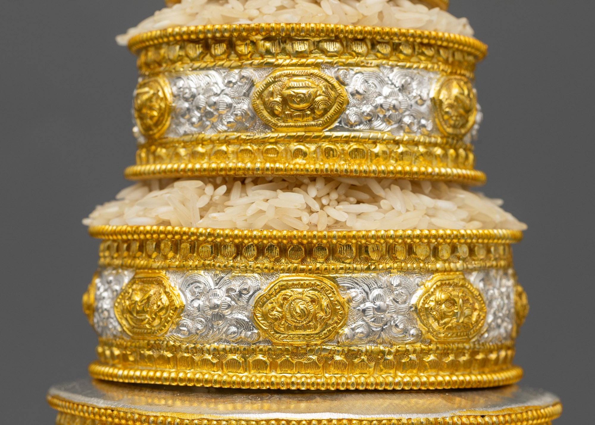 Close up of stackable copper rings with gold-plated symbols on Tibetan Mandala set