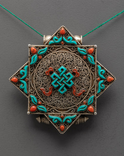 Close up of turquoise Endless Knot centerpiece on silver-plated filigree locket design
