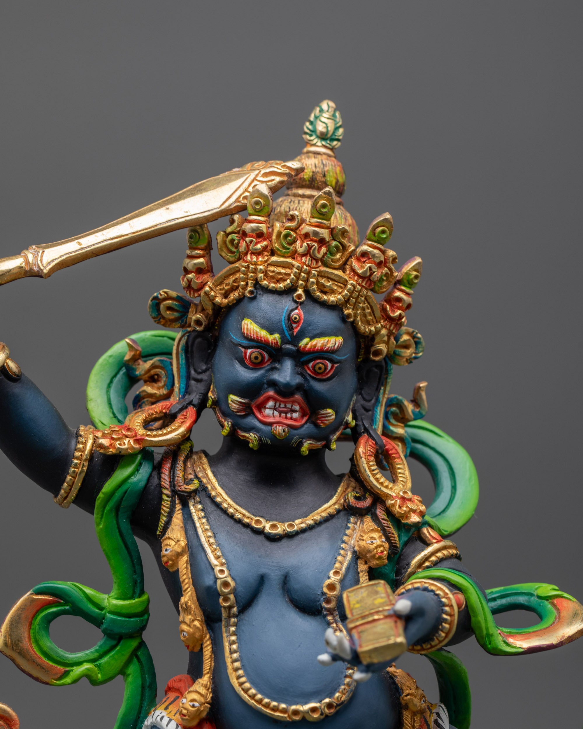 Close up of wrathful Manjushri holding Sword and Prajnaparamita Sutra with skull crown
