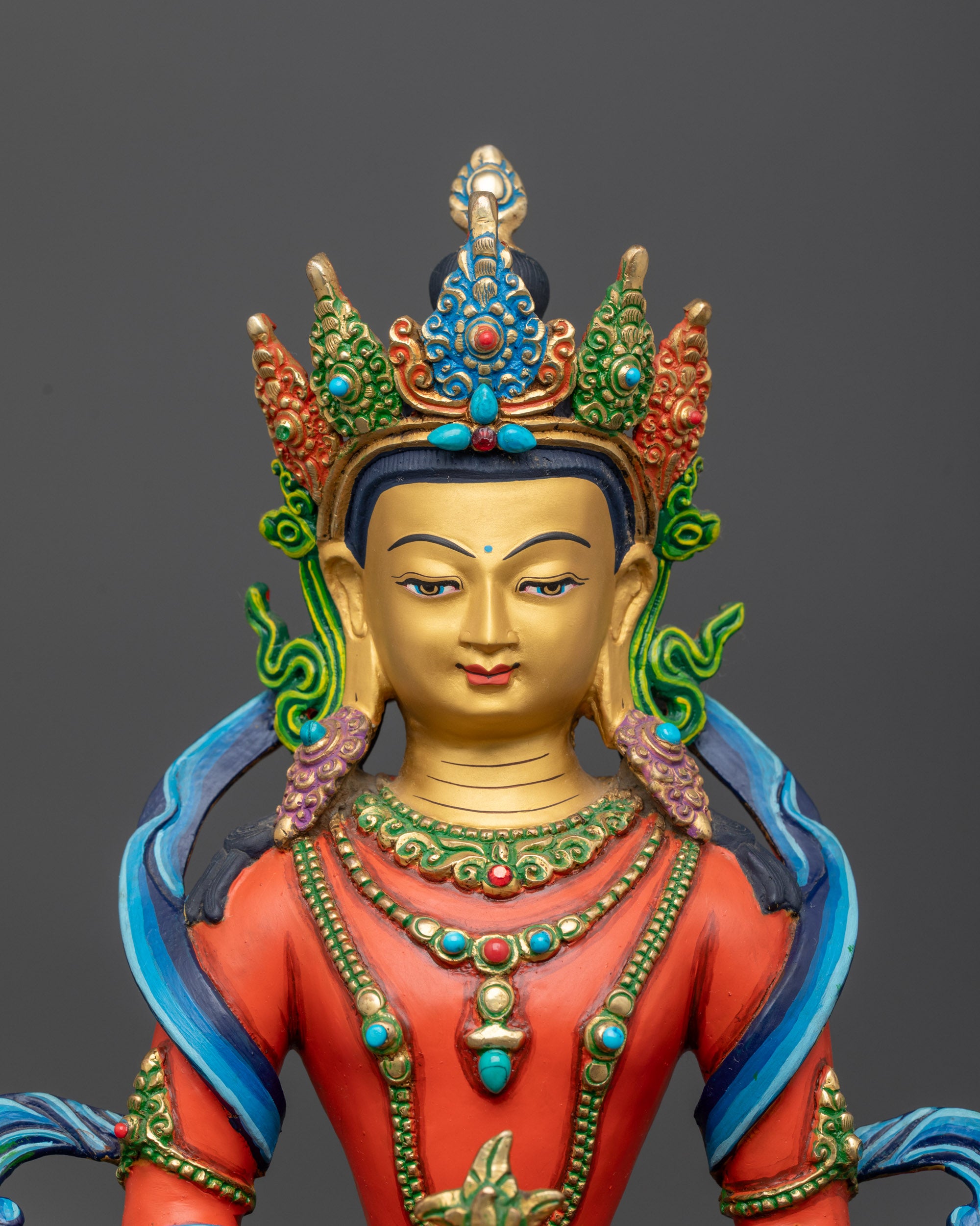 Close up on the gold gilded face and nectar vase of the Amitayus longevity statue.
