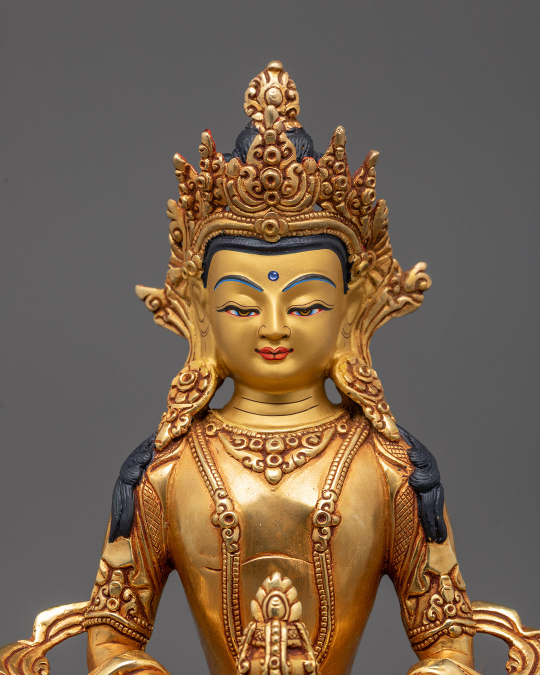 Closeup of Amitayus statue’s sacred Nectar Vase and intricate crown carvings
