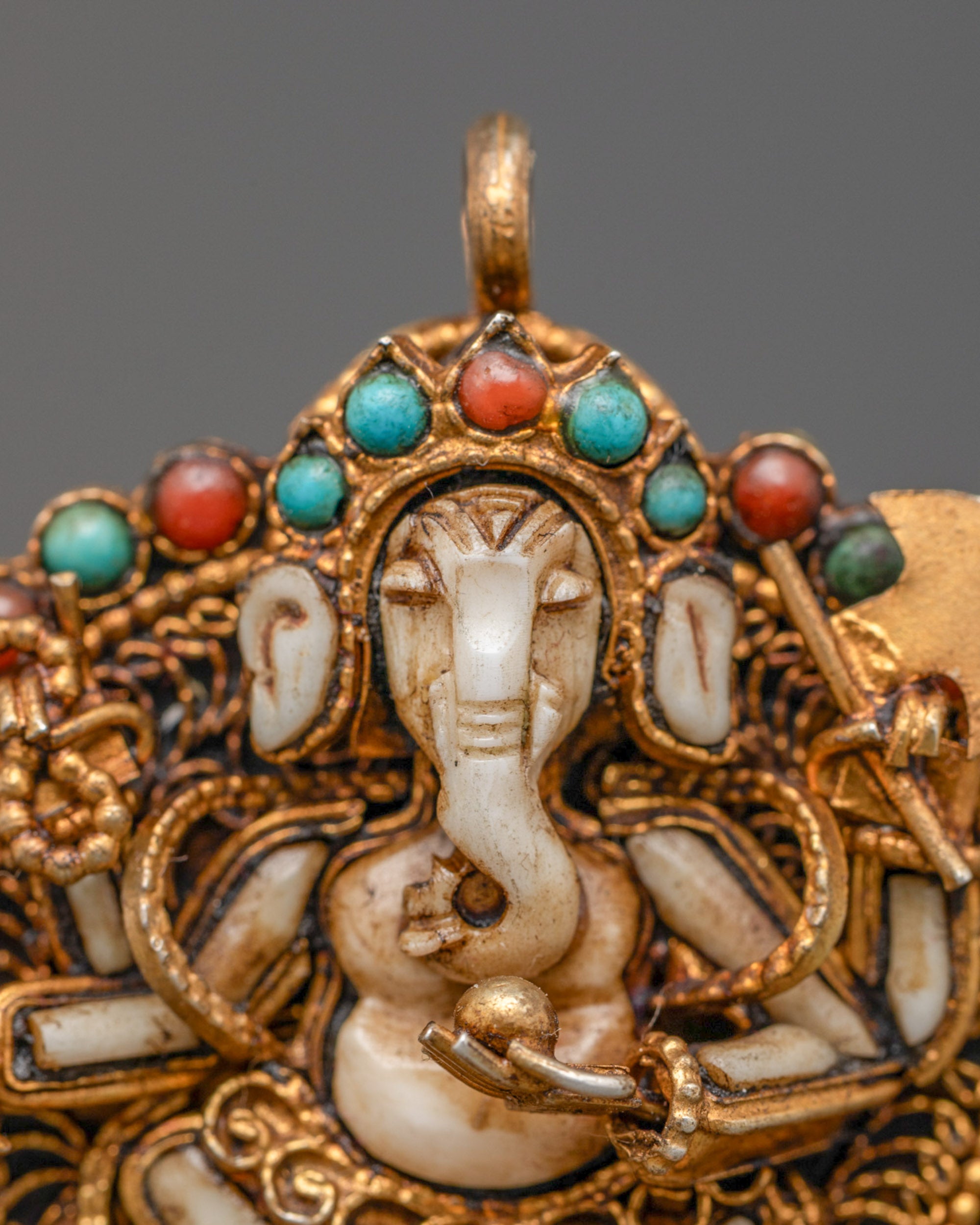 Closeup of Ganesh pendant showing intricate filigree work and semi-precious stone details