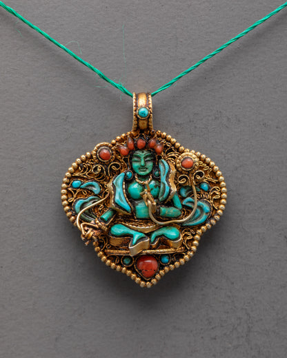 Closeup of Green Tara Amulet, showing intricate filigree work, radiant green crystal Tara, and detailed semi-precious stone inlays.
