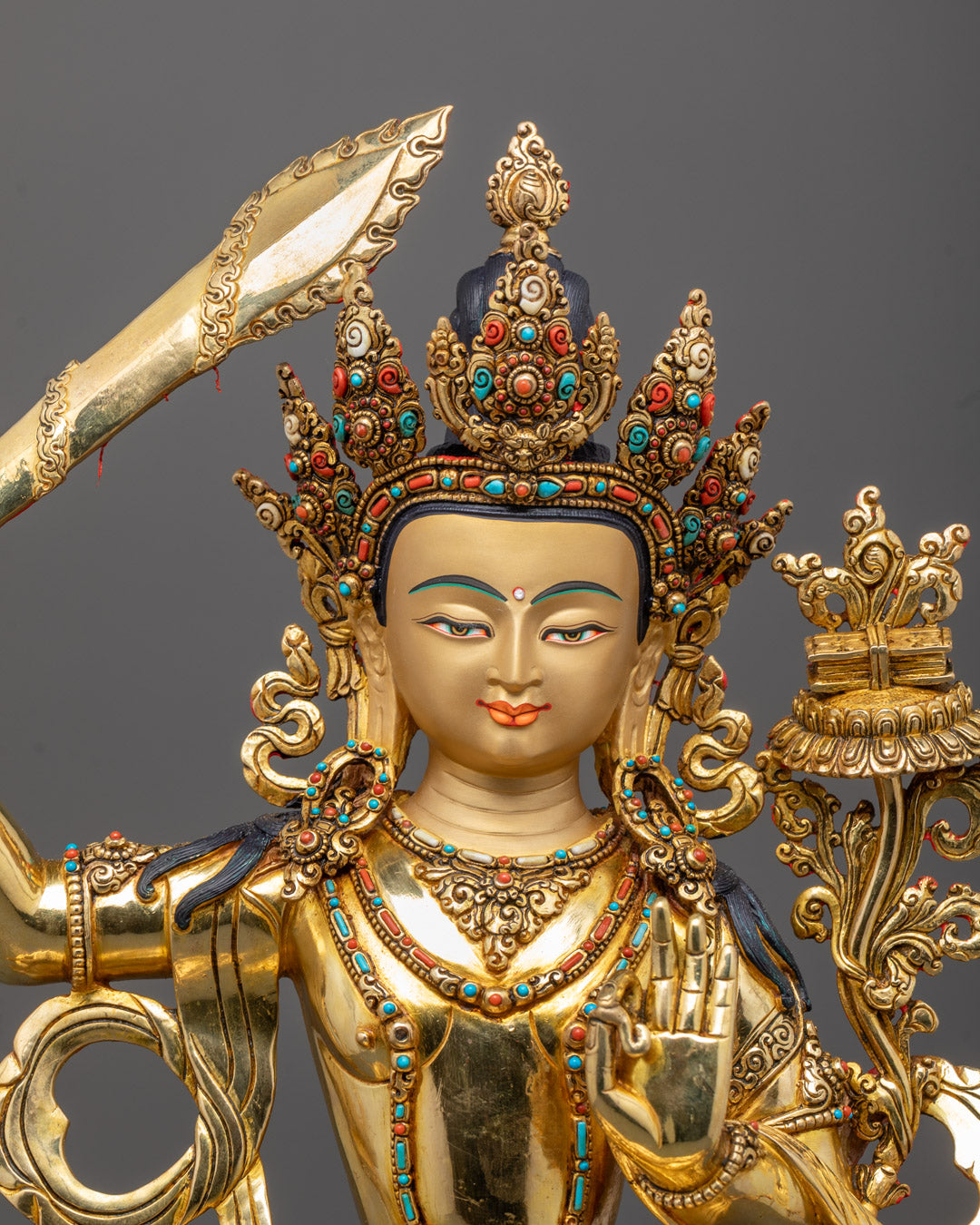 Closeup of Manjushri statue’s gold-gilded face and intricately carved halo details