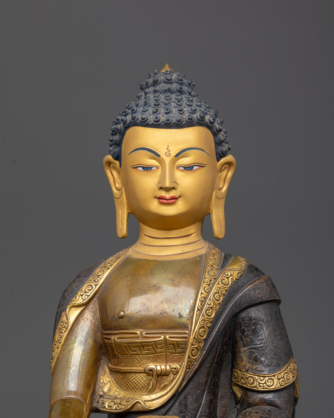 Closeup of Shakyamuni Buddha face and patra bowl with 24K gold gilding details