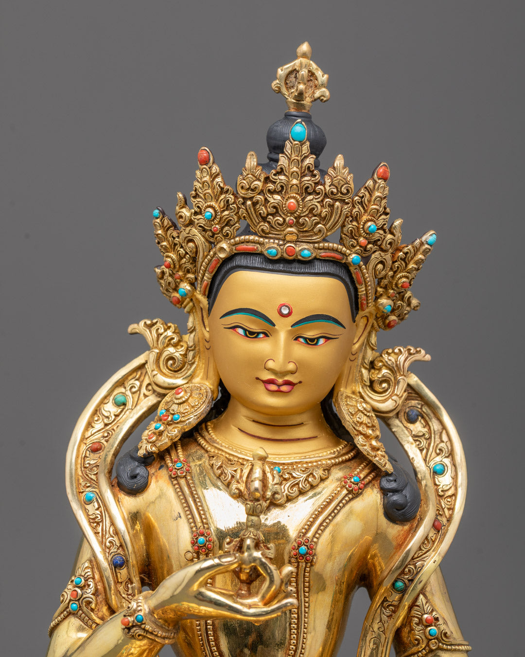 Closeup of detailed carvings and semi-precious stones on Vajrasattva’s crown and robe