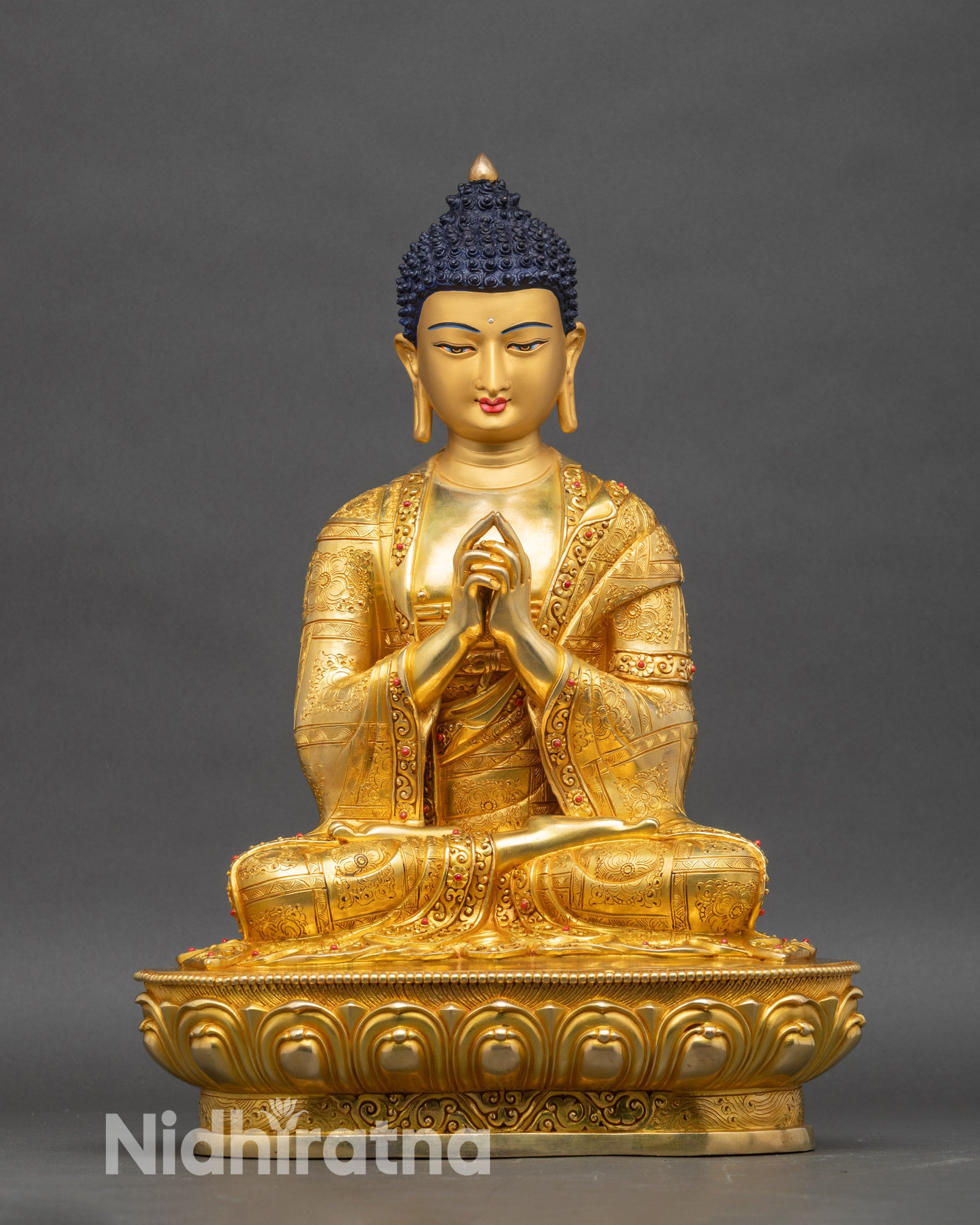 Cosmic Vairocana Buddha statue with four gold-painted faces and lotus pedestal