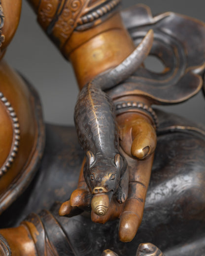 Detail of Dzambhala’s hands holding citron fruits and jewel-spitting mongoose, symbolizing wealth and generosity