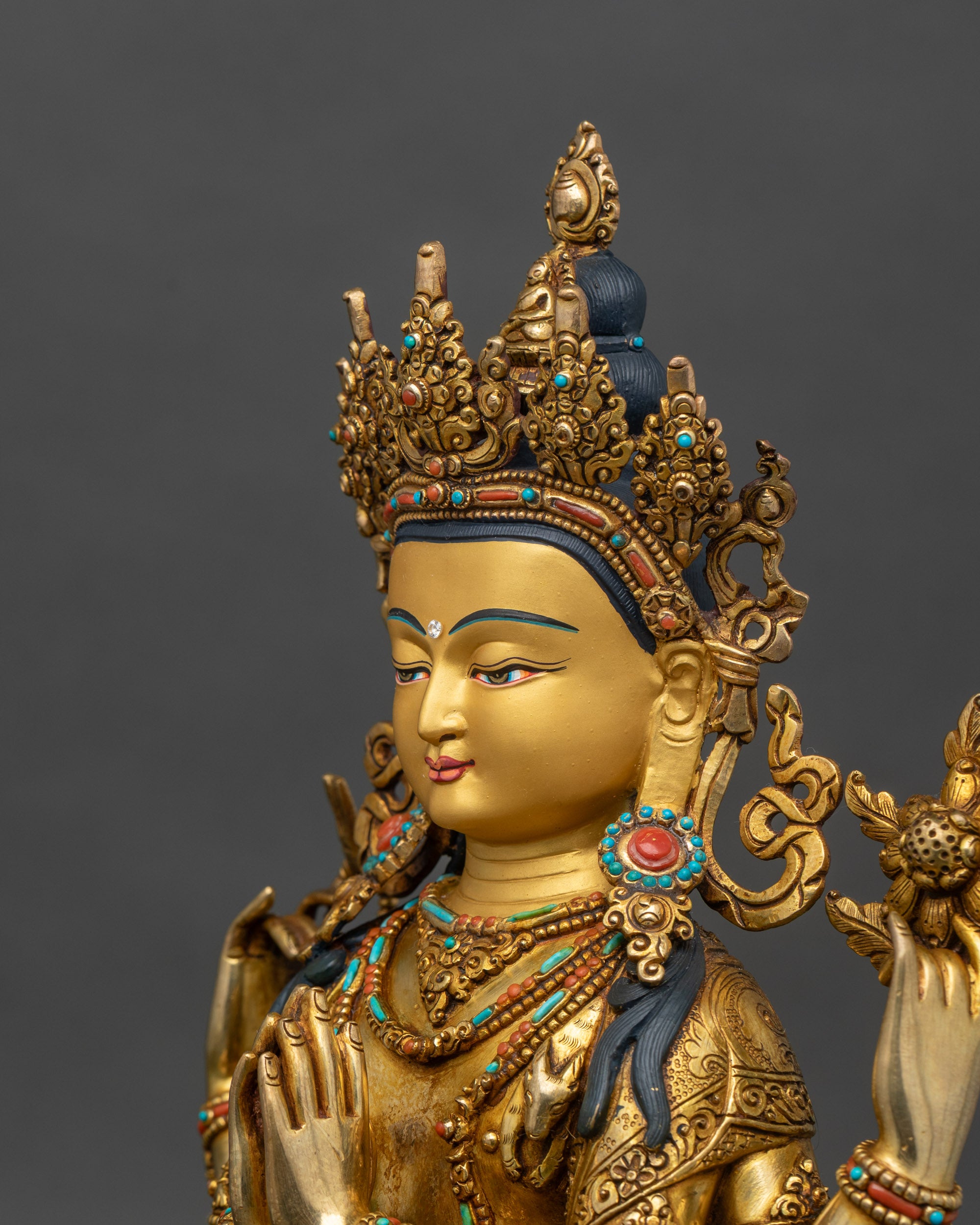 Detailed side close-up of Avalokiteshvara statue on ornate lotus pedestal, vibrant stones