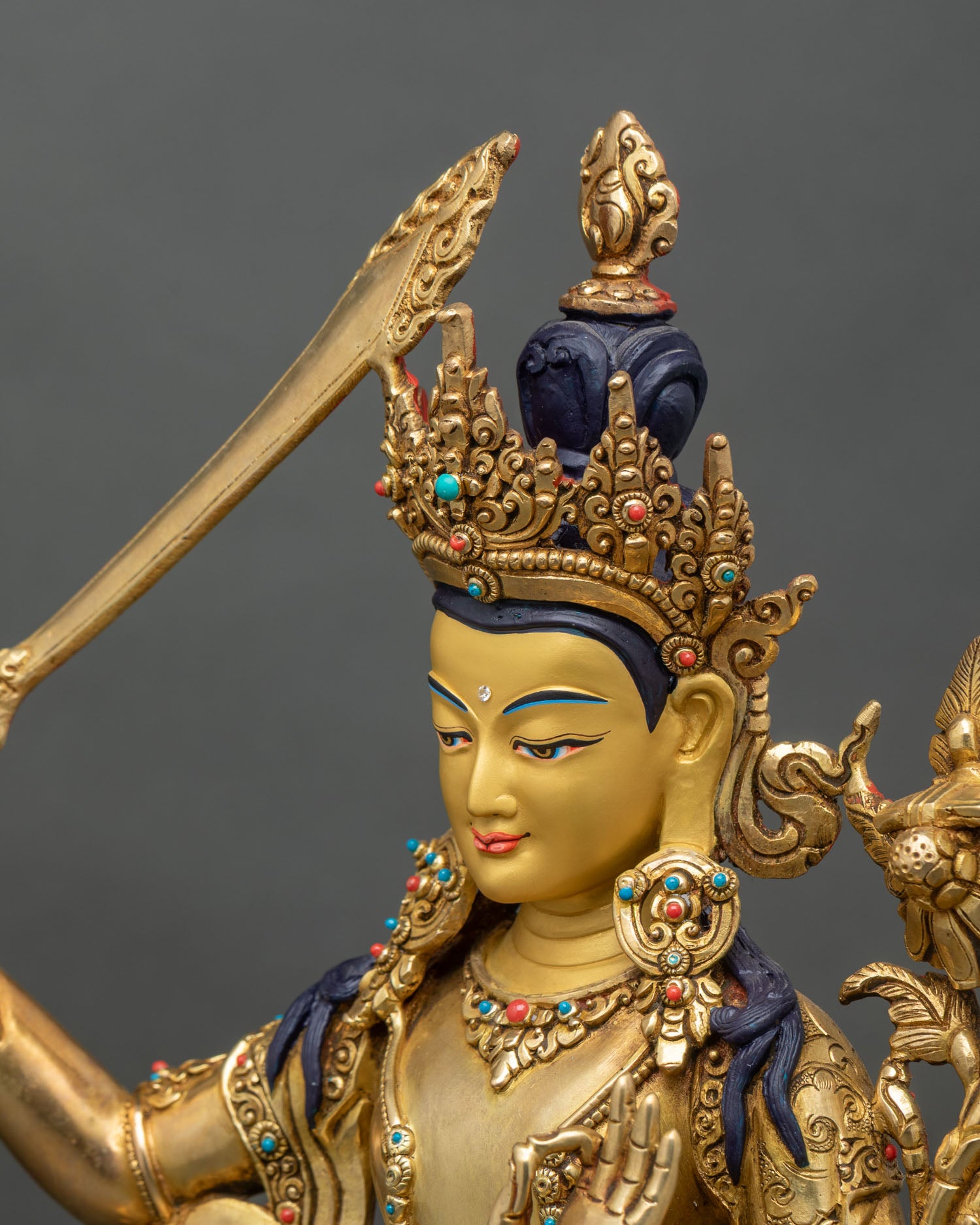 Detailed side close-up of Manjushri statue with flaming wisdom sword and jewelry