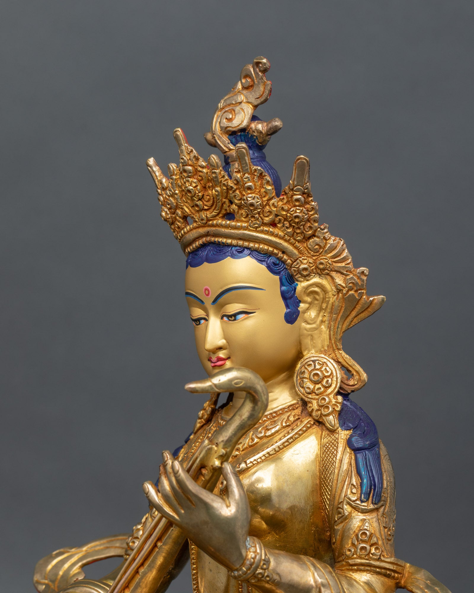 Detailed side close up of Saraswati statue with veena and ornate lotus throne carving