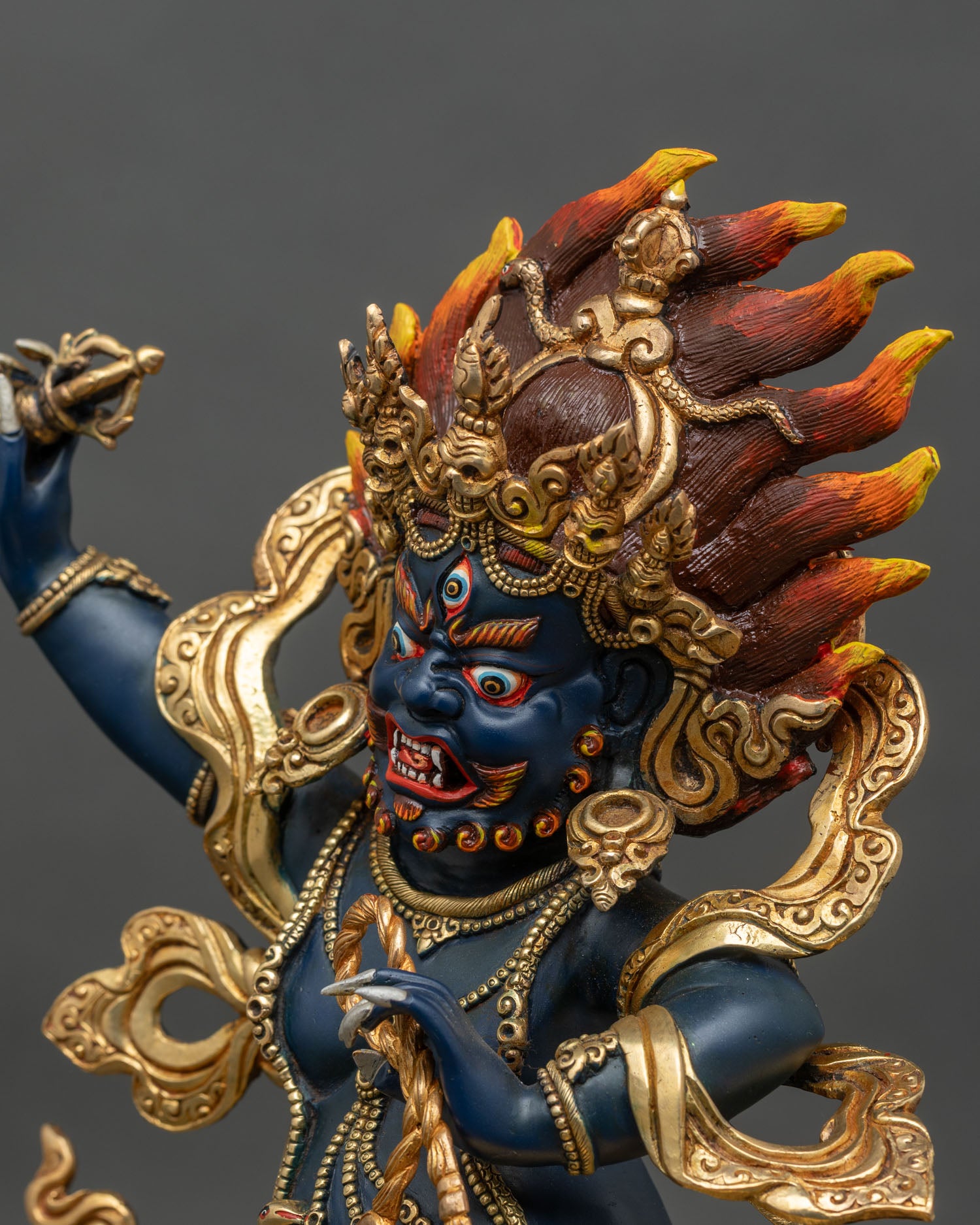 Detailed close-up of Vajrapani face, wrathful expression with hand-painted blue and gold