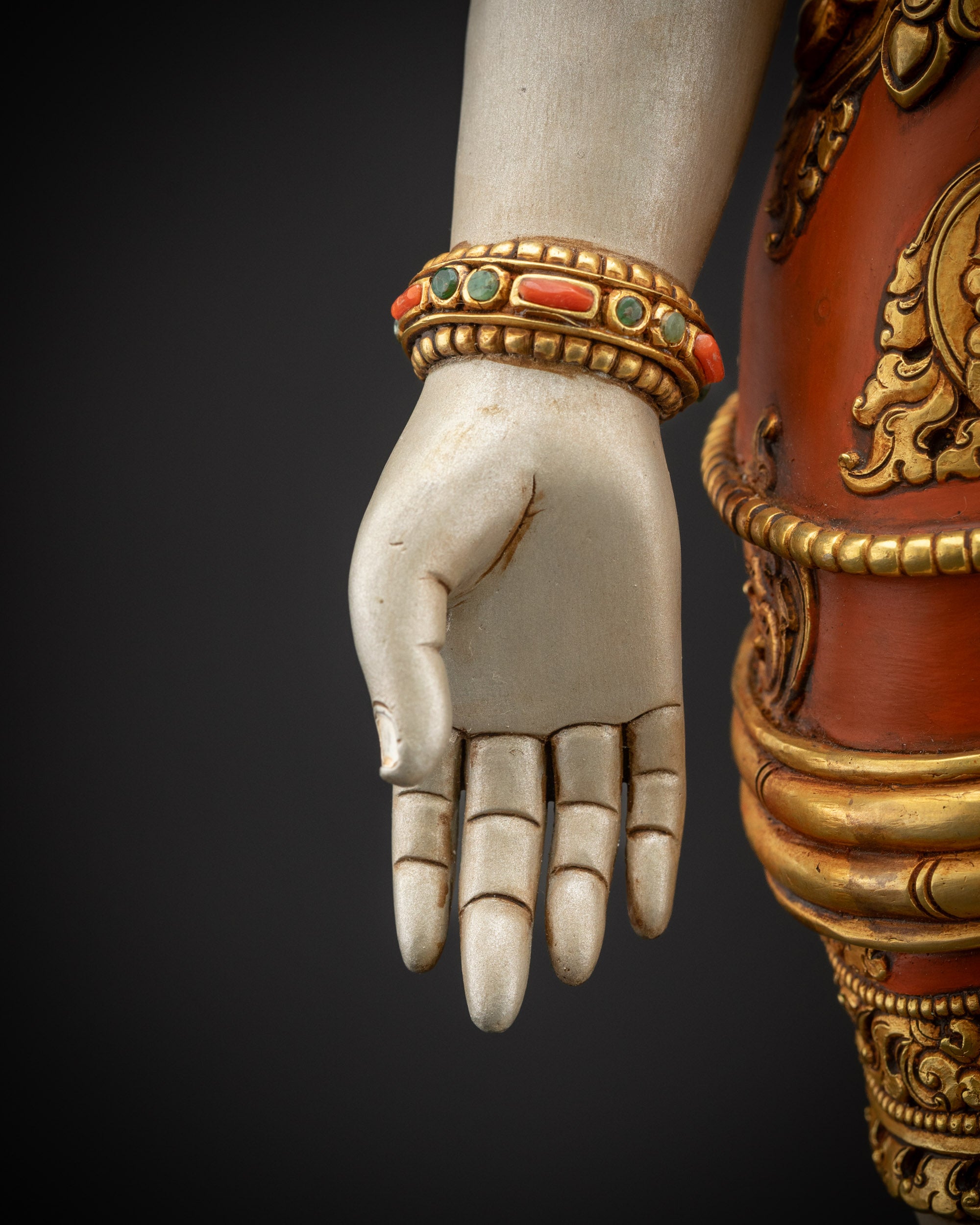 Detailed armlets close up of Lokeshvara statue with gold-gilded accents