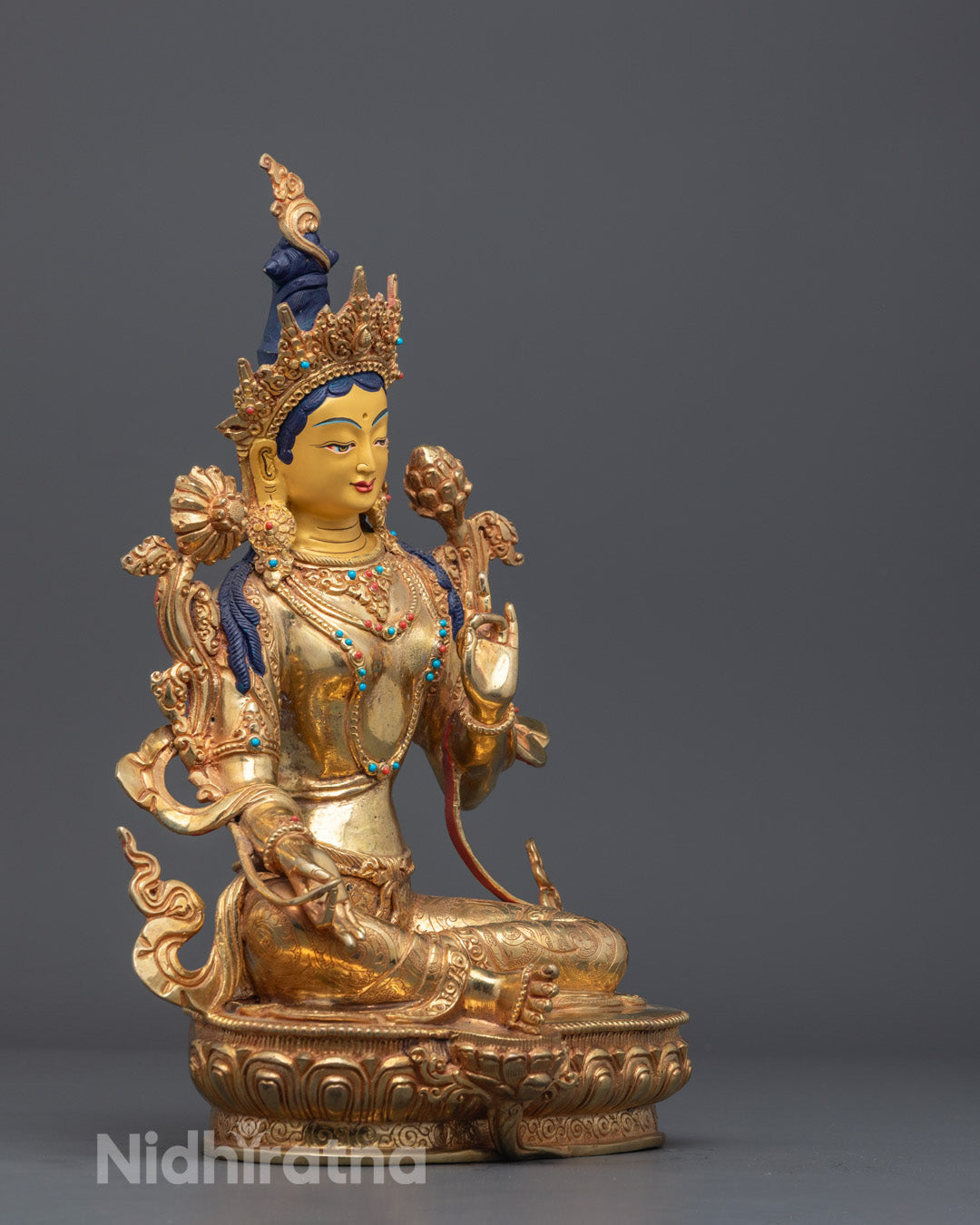 Detailed carving of Samghati robe, crown, and jewelry on Himalayan Green Tara statue