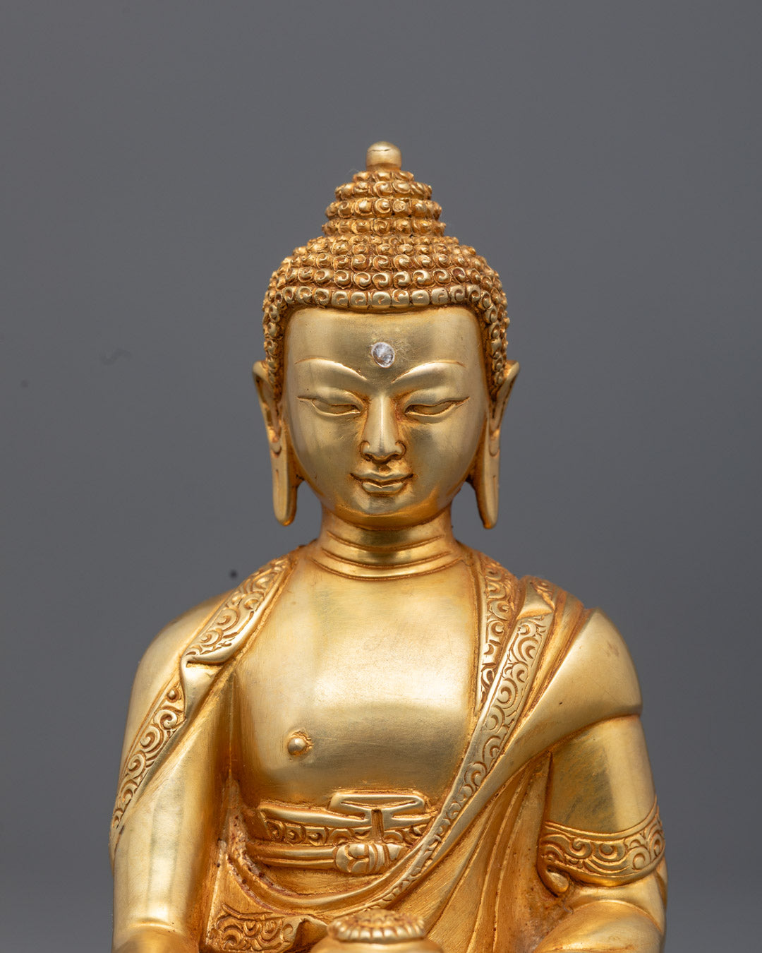 Detailed carving on Sanghati robe and sacred Patra begging bowl of Earth Touching Buddha statue painted with vibrant acrylic colors