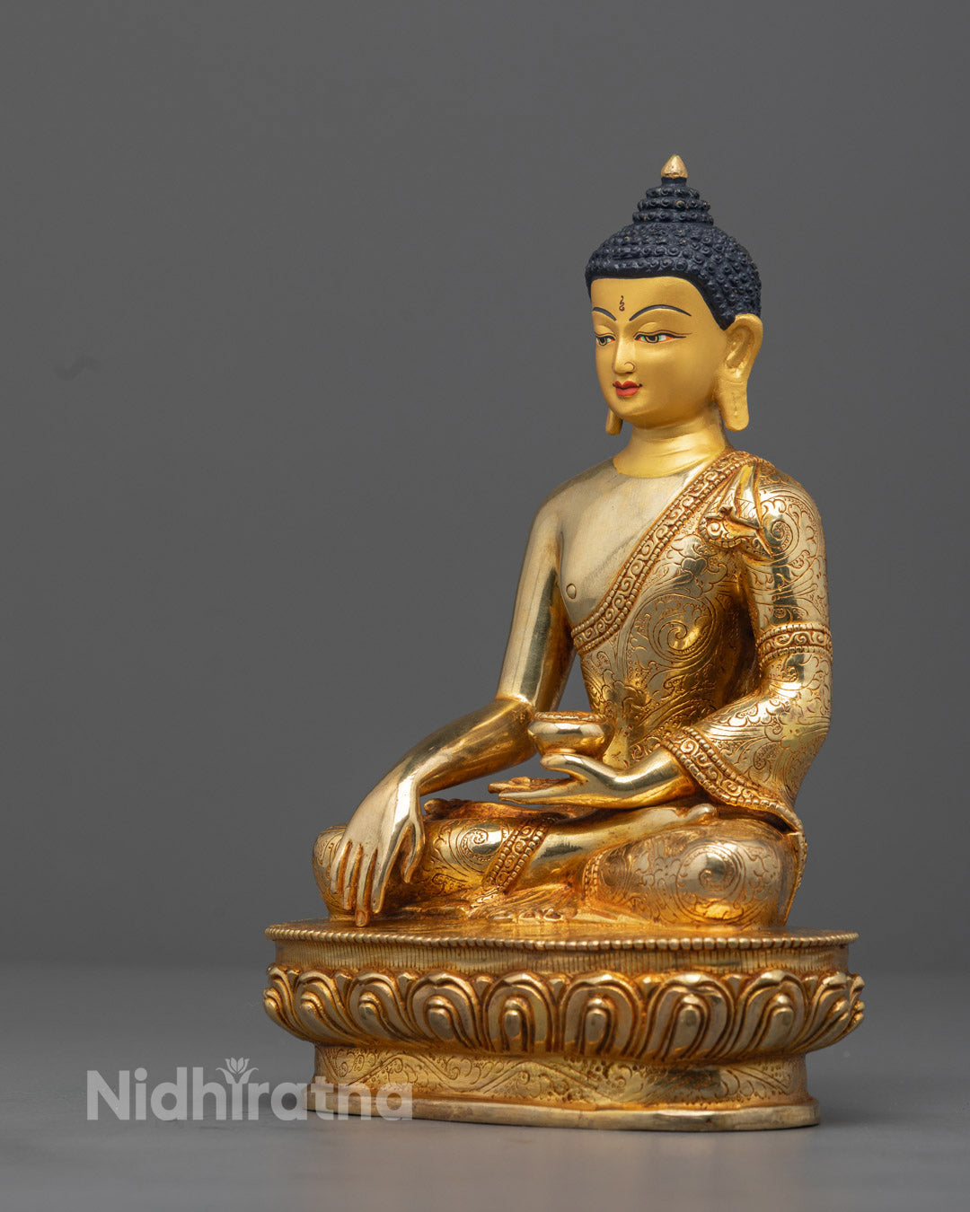Detailed carving on the robe of Authentic Gautam Buddha Statue made using traditional lost wax casting method by skilled Nepalese artisan.