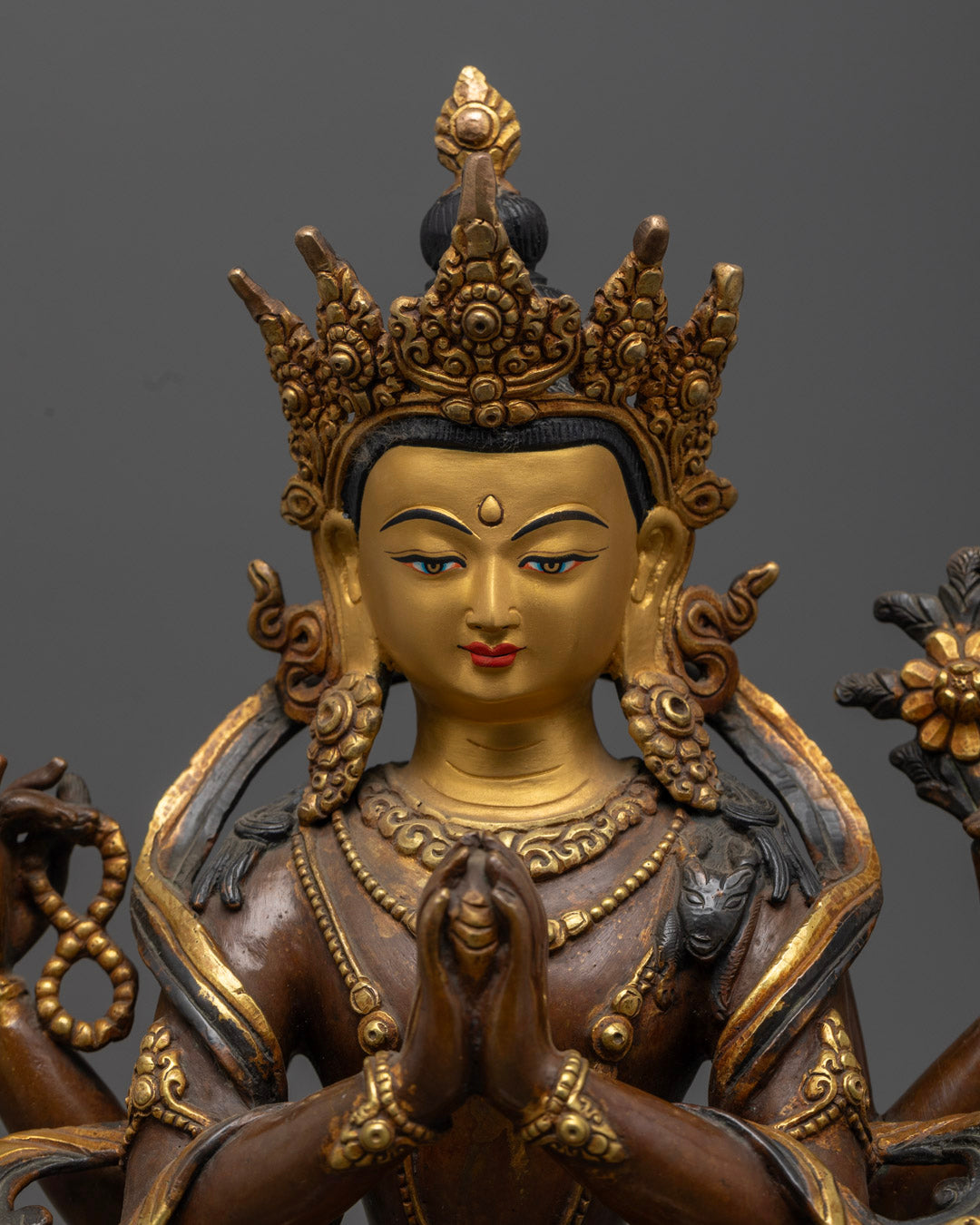 Detailed carvings on the robe and jewelry of the Chenrezig statue, enhanced with vivid acrylic colors showcasing skilled Nepalese craftsmanship.