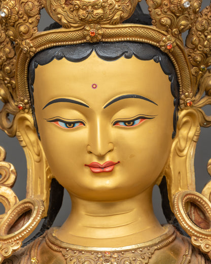 Detailed close-up face of Green Tara statue with serene expression and gold fire-gilding