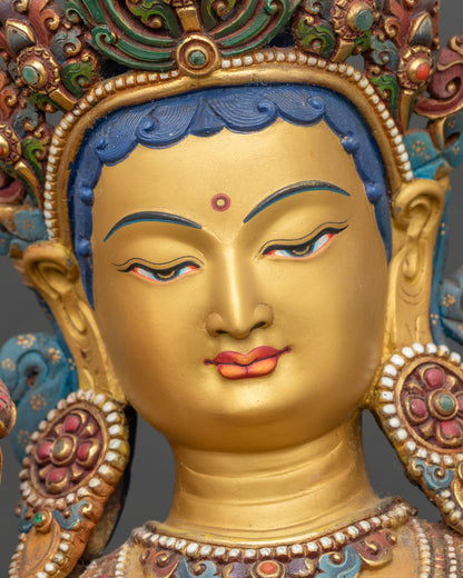 Detailed close-up face of Green Tara statue with serene expression and gold-painted face