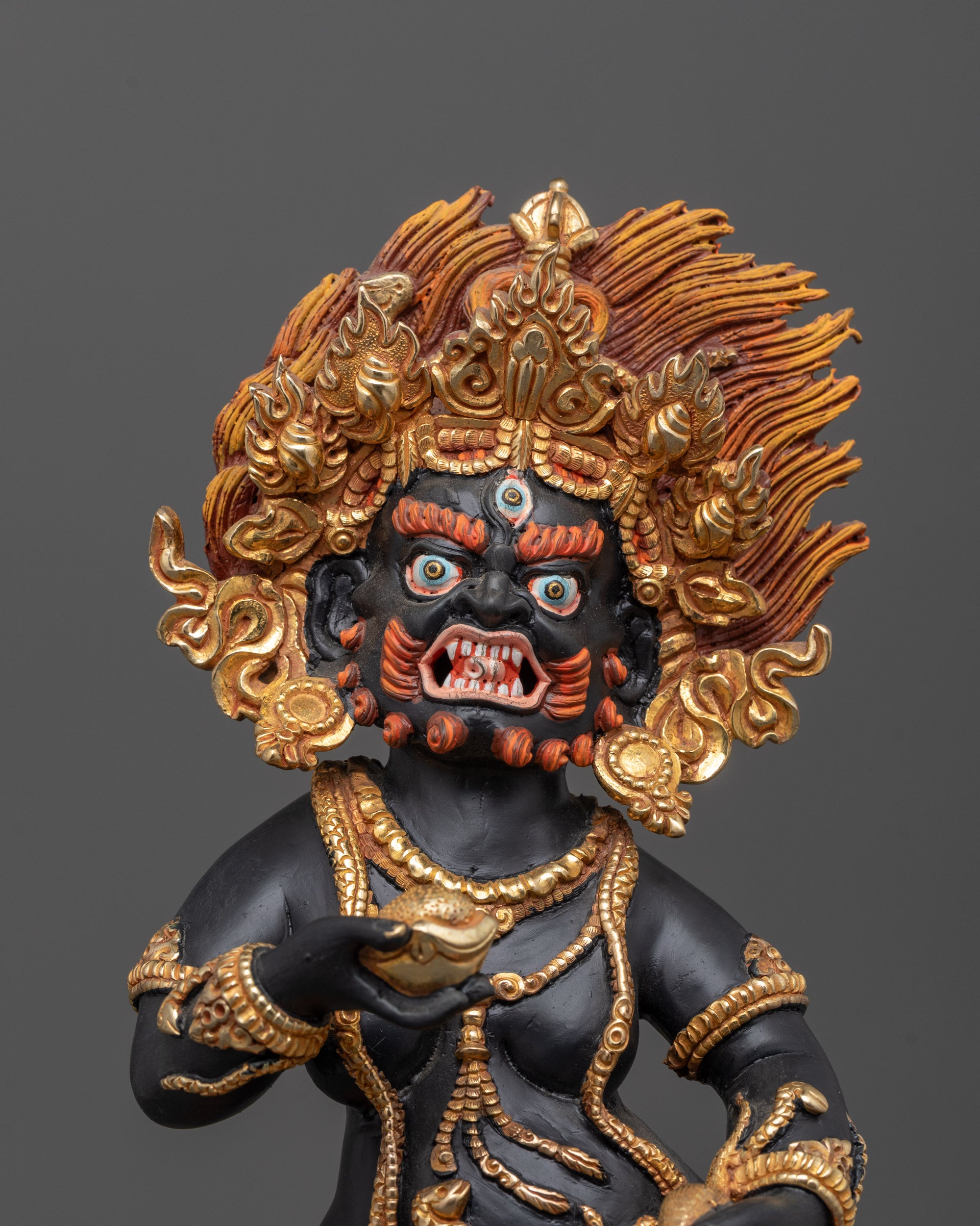 Detailed close-up of Black Dzambhala holding citron fruit and mongoose
