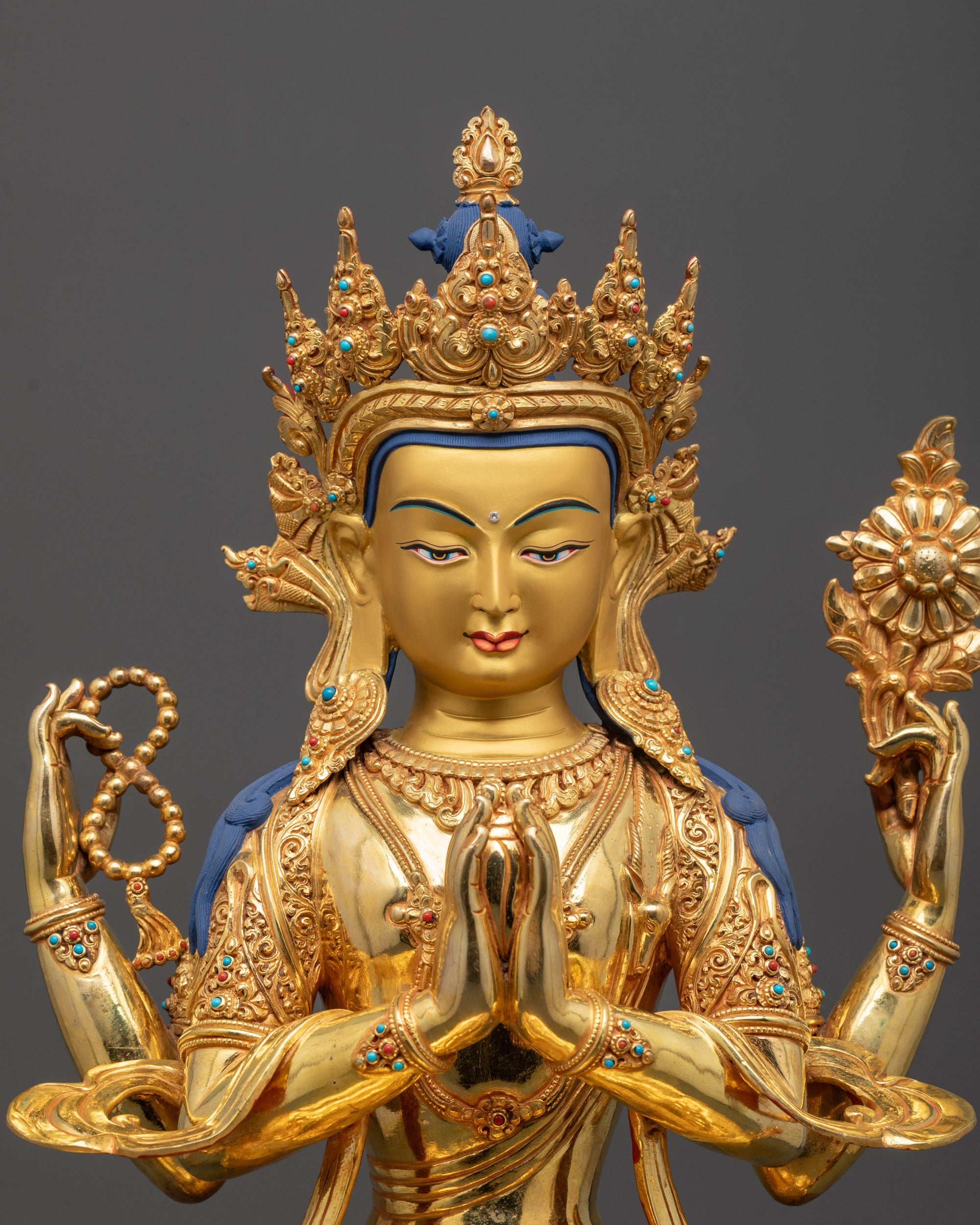 Detailed close-up of Chenrezig Statue face and hands with silver plating highlighting