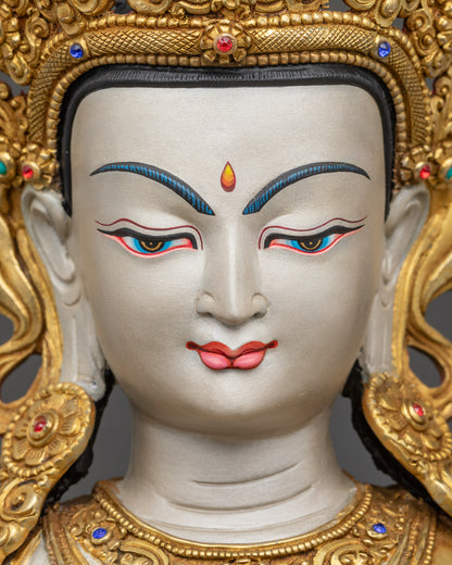 Detailed close-up of Chenrezig Statue face, serene expression with gold-gilded crown features