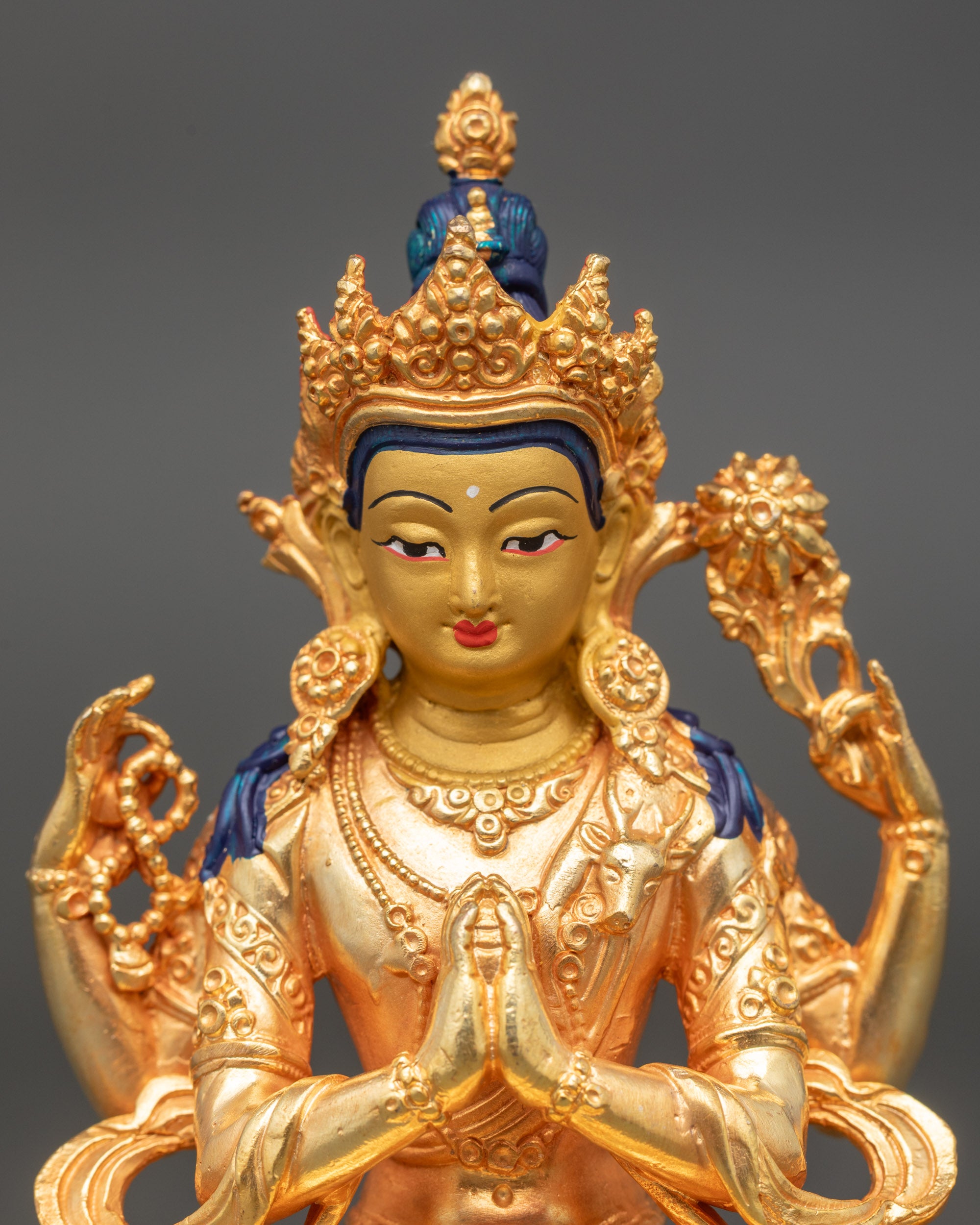 Detailed close-up of Chenrezig face with gold paint and serene compassionate expression