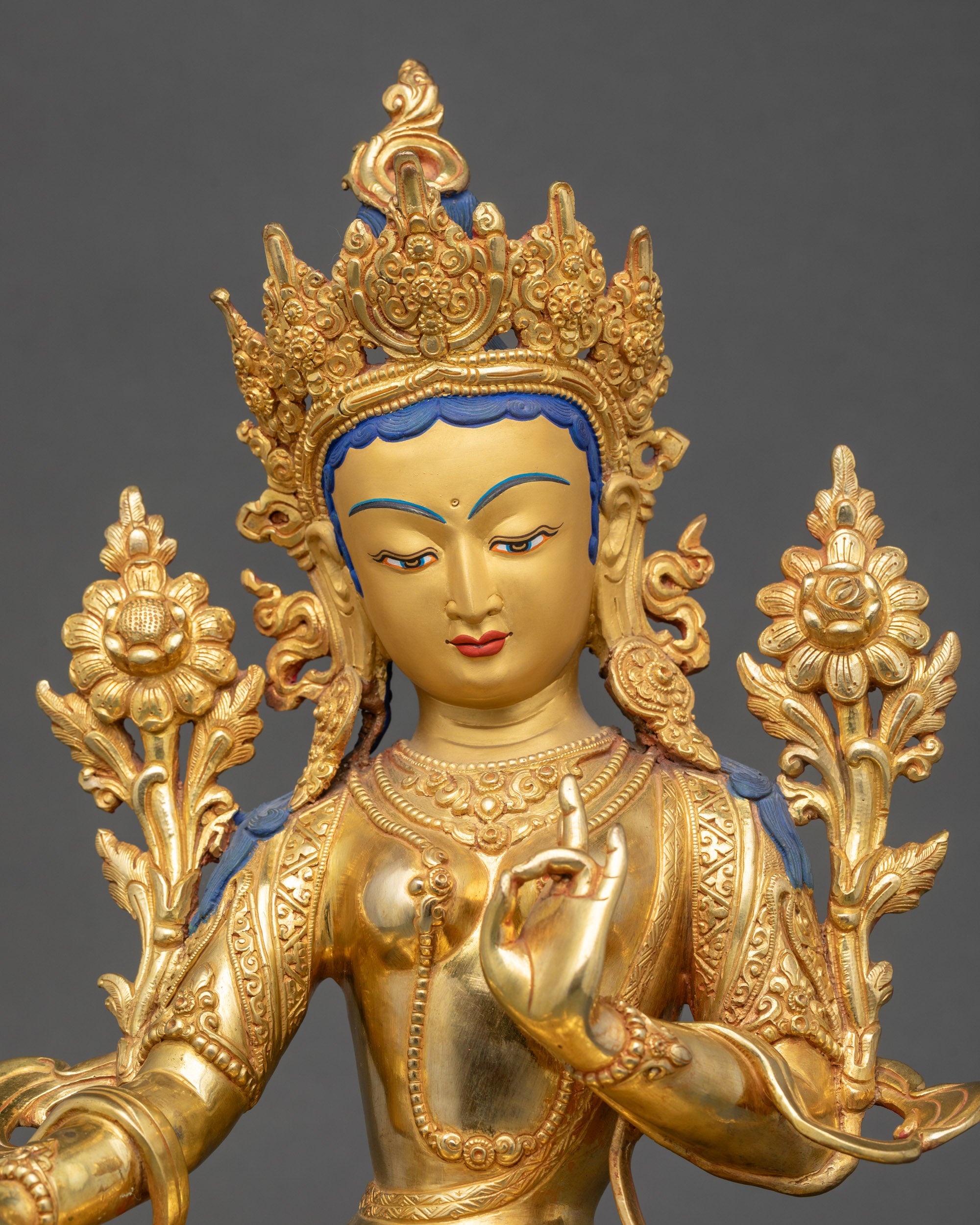 Detailed close-up of Green Tara Bodhisattva face, serene expression with gold finish