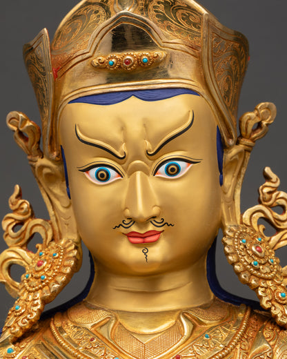 Detailed close-up of Guru Rinpoche Statue face with serene expression and gold-painted features