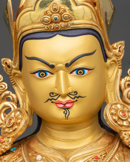 Detailed close-up of Guru Rinpoche face, gold fire-gilded copper with serene expression and crown details