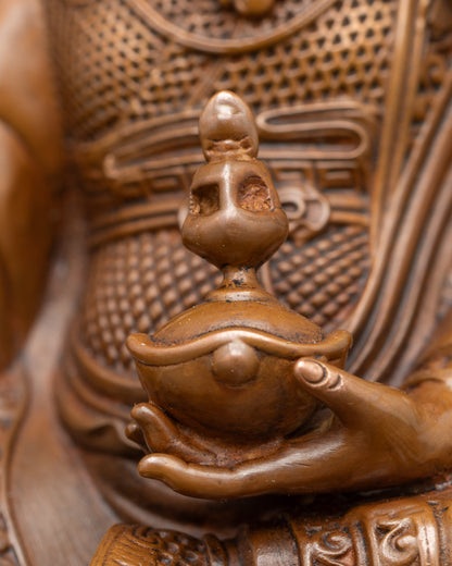 Detailed close-up of Guru Rinpoche’s vajra and skull cup on oxidised Himalayan statue