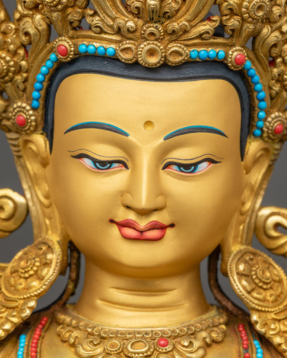 Detailed close-up of Manjushri statue face with peaceful expression and gold-gilded finish