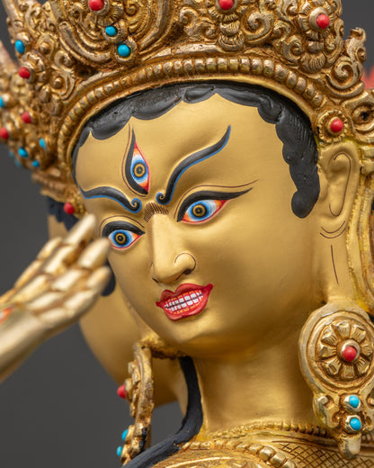 Detailed close-up of Namgyalma statue face with three expressive gold-painted heads, symbolizing wisdom and longevity