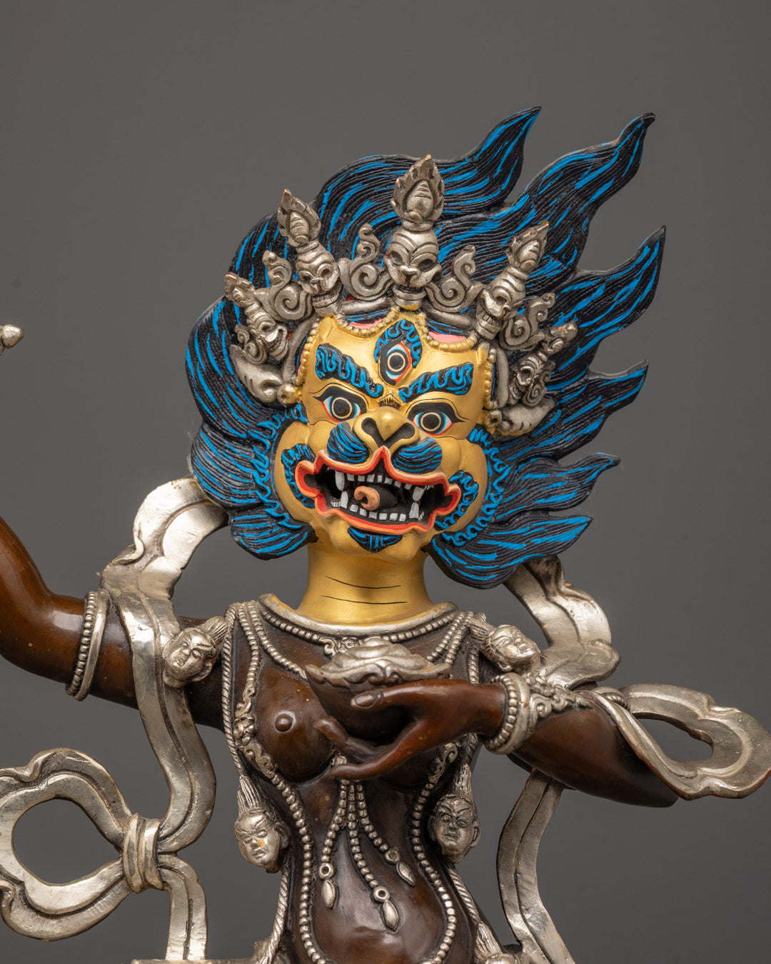 Detailed close-up of Singha Mukha's gold-gilded face with lion features
