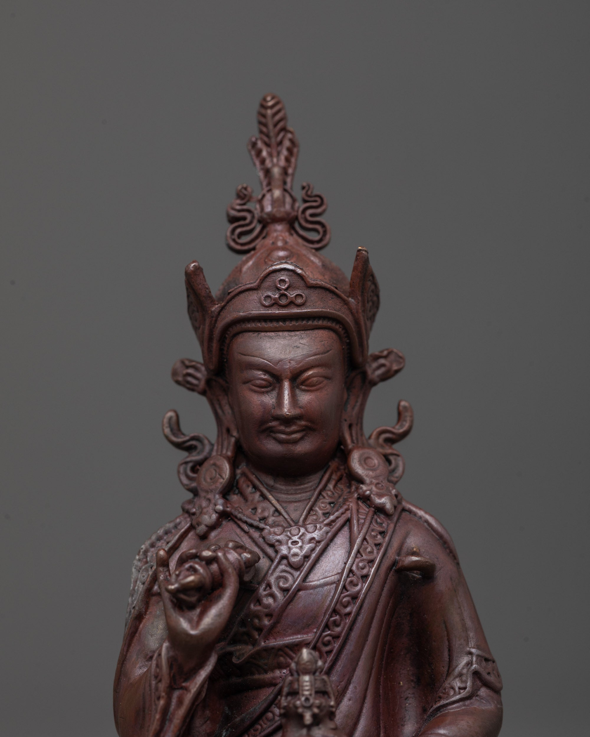 Detailed close-up of Tsokye Dorje gold-painted face and five-petaled lotus hat, Nepalese devotional Buddhist artwork