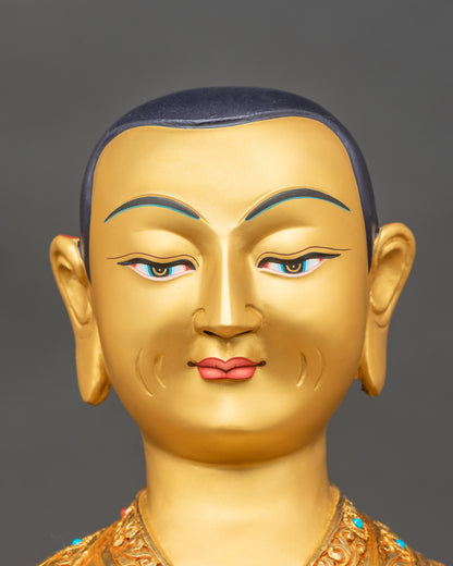 Detailed close-up of Tsongkhapa face, gold-painted features, peaceful expression