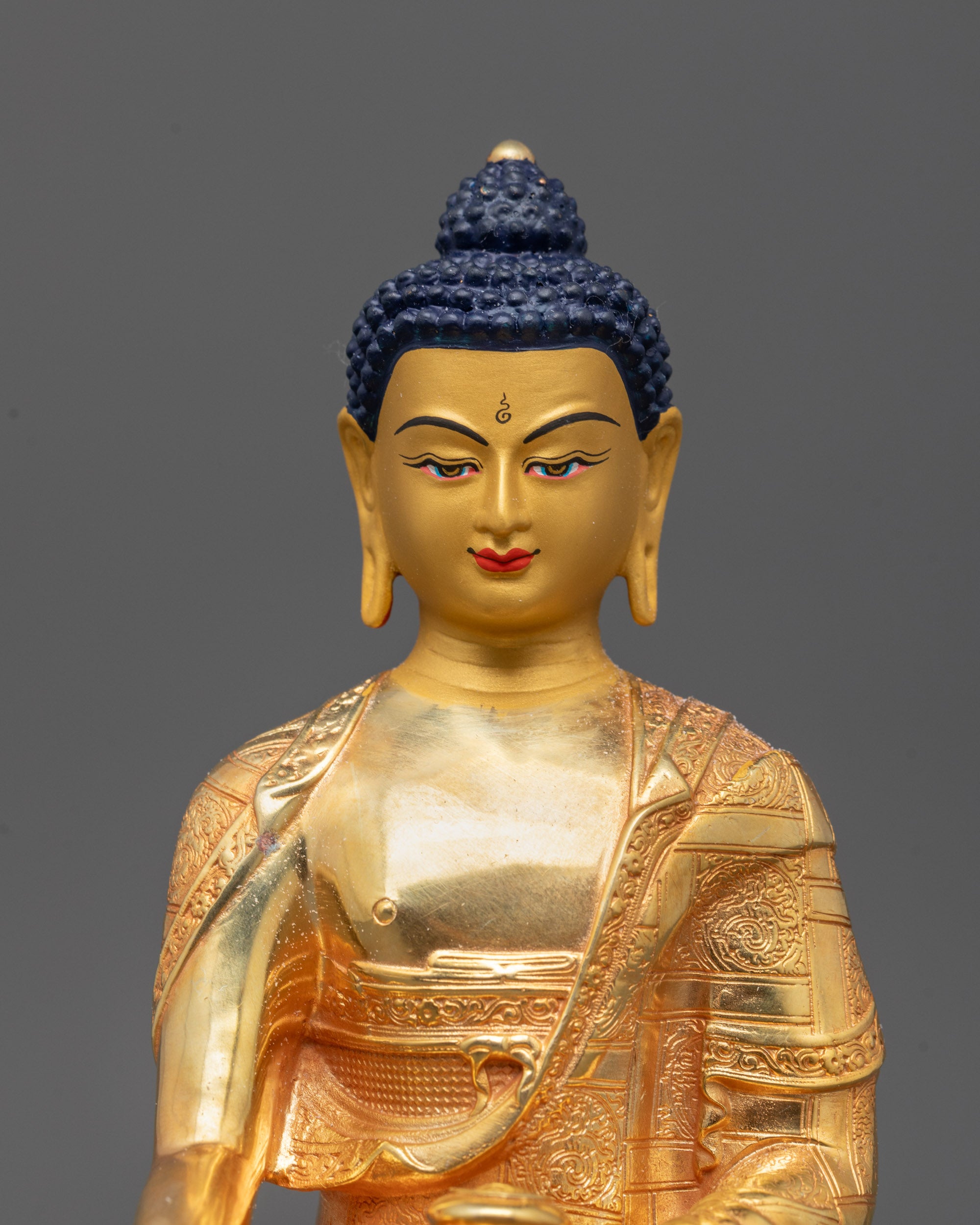 Detailed close-up showing the serene expression of Shakyamuni Buddha with soft golden finish