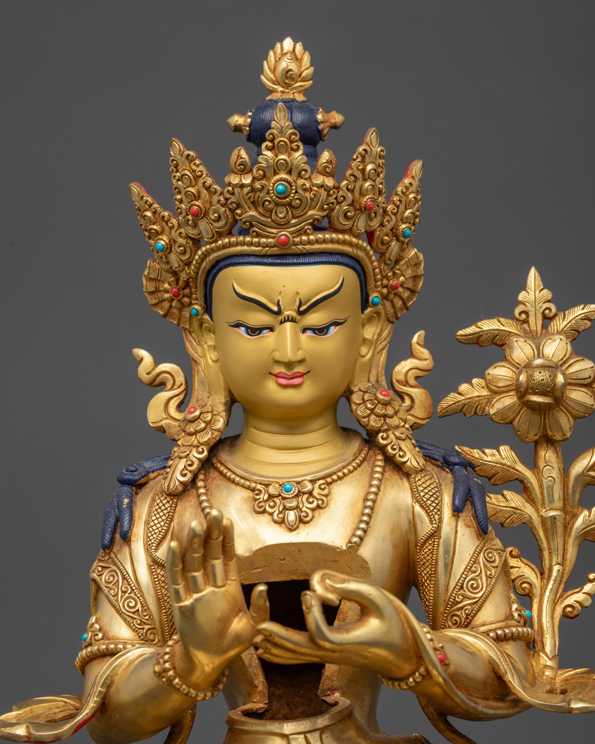 Detailed close up Buddha face gold gilded crown with semi precious stones