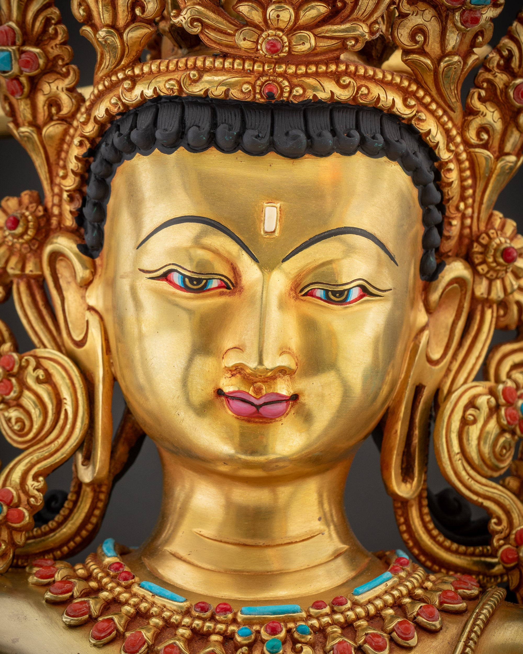 Detailed close up Maha Manjushri Statue serene fire gold gilded face handcrafted by Nepalese artisans

