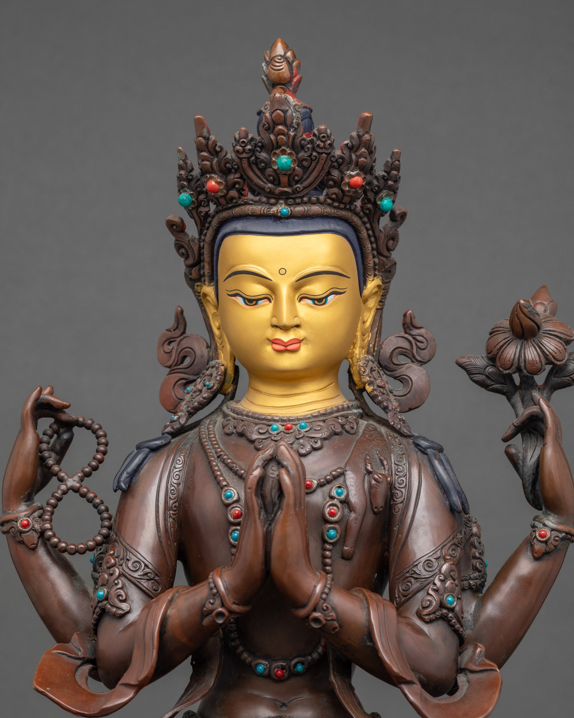 Detailed close up face – Chenrezig statue face with serene expression and gold paint details
