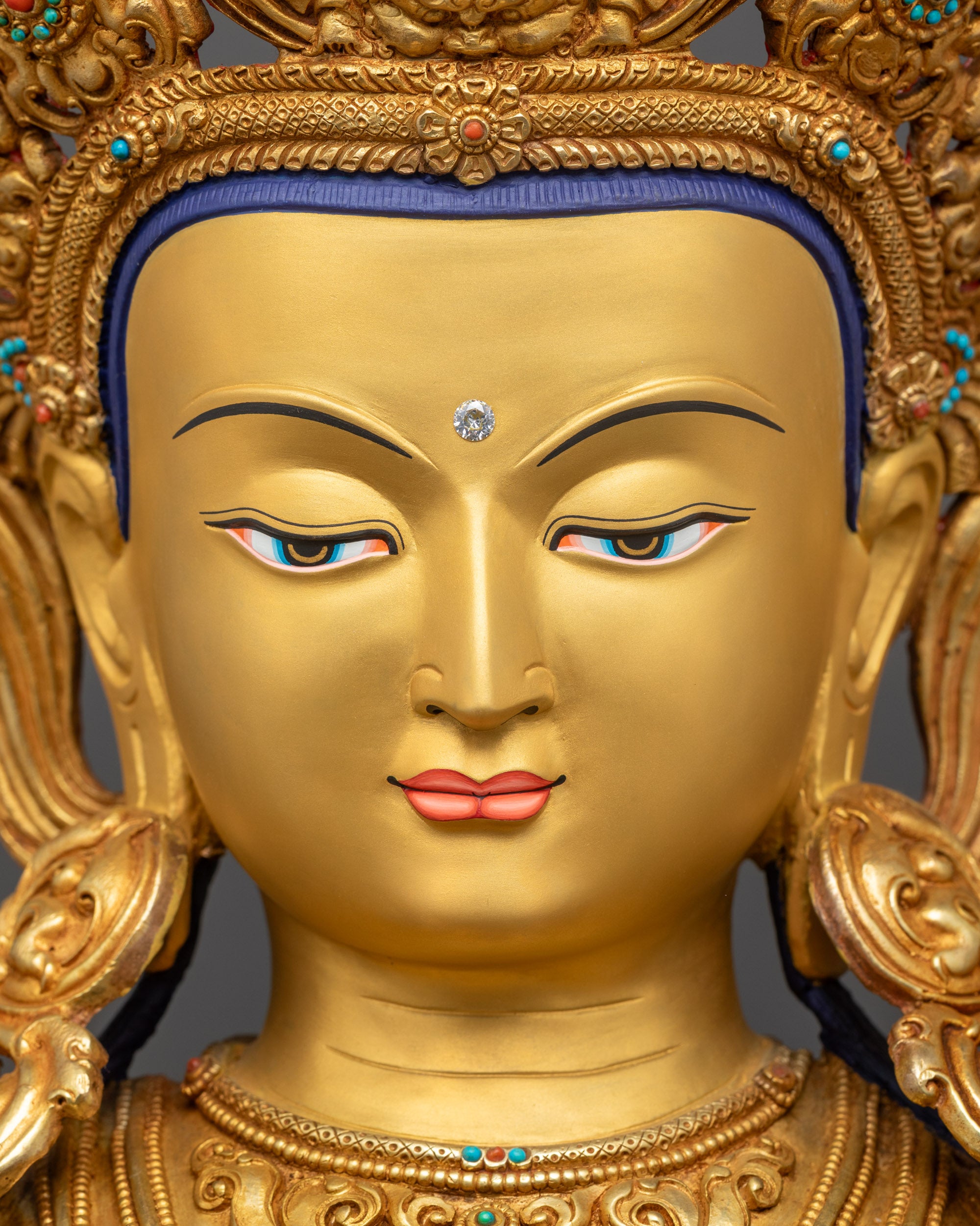 Detailed close up face Chenrezig statue serene gold-gilded Avalokiteshvara face